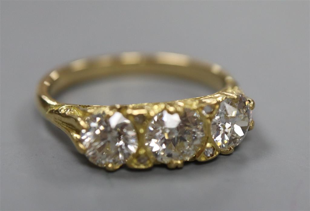 A Victorian style yellow metal and three stone diamond ring with diamond chip spacers, size Q, gross 4.5 grams.